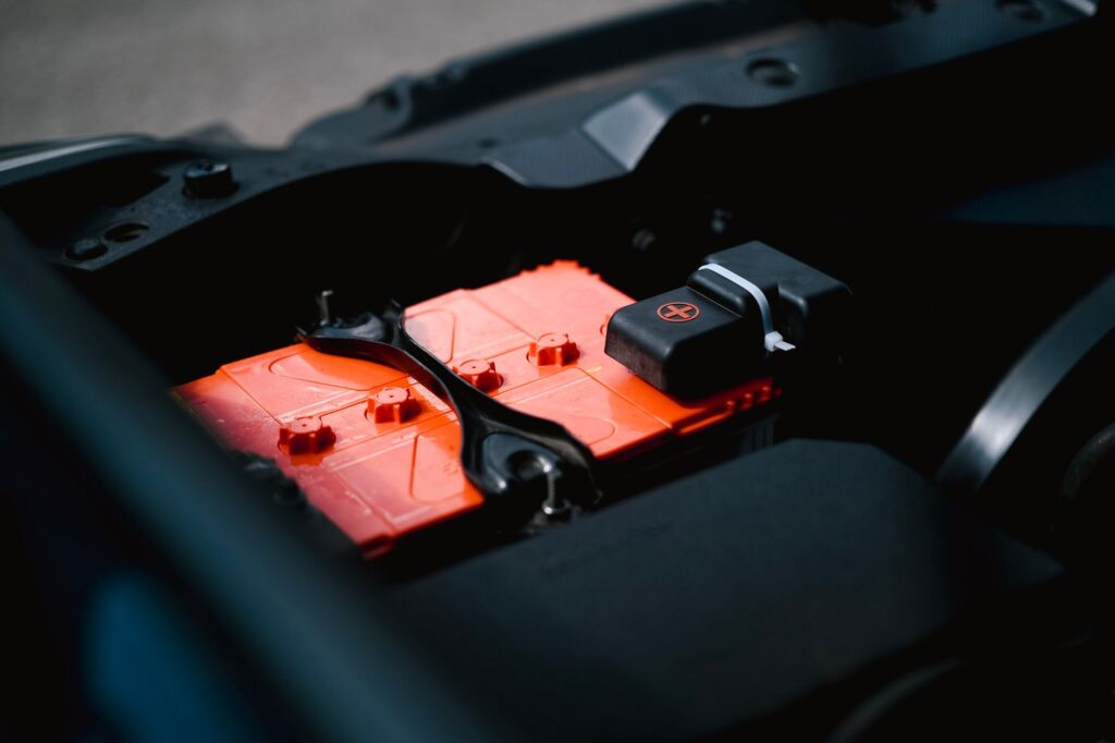 Batterie de voiture en place dans le compartiment moteur, cosses visibles